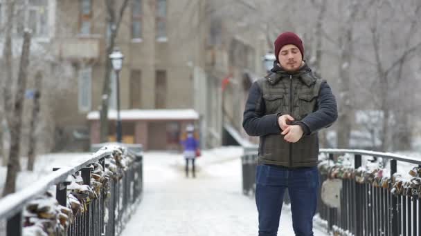 Νεαρός άνδρας που περιμένει κάποιος στην πόλη χειμώνα — Αρχείο Βίντεο