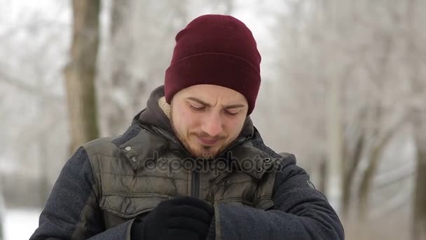 Молодой человек ждет кого-то в зимнем городе — стоковое видео