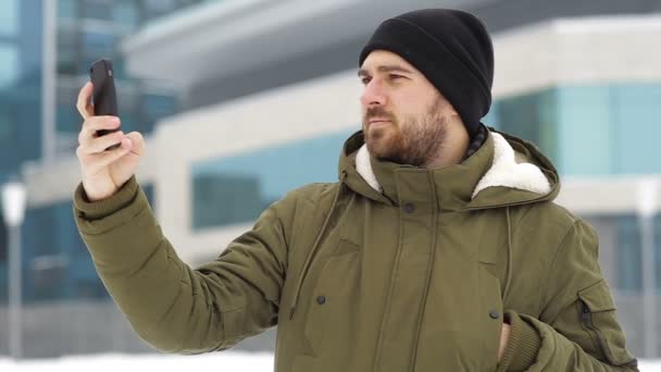 Hombre hablando en un teléfono móvil en invierno outdors — Vídeo de stock