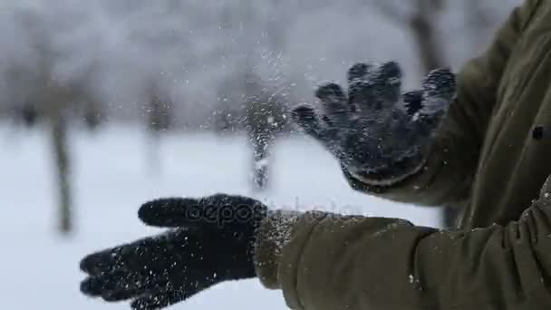 Manos de hombre con guantes sacudiendo nieve al aire libre en invierno — Vídeo de stock