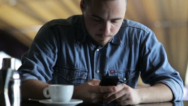 De man belt sms zitten aan de bar — Stockvideo