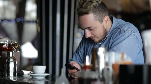 Mannen ringer upp sms som sitter vid baren — Stockvideo