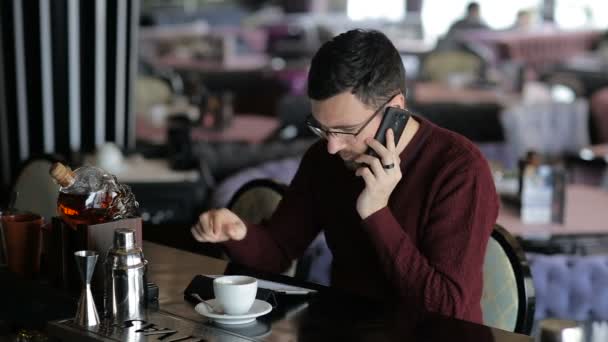 Мужчина разговаривает по смартфону в баре — стоковое видео