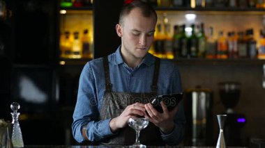Genç barmen keşfetmek yeni kokteyl tablet kullanma