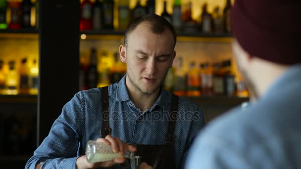 El camarero y el cliente se comunican en el bar durante la preparación del cóctel — Vídeo de stock