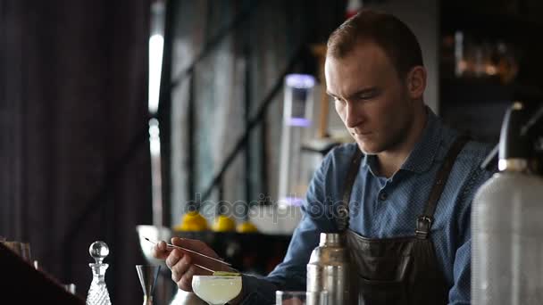 De jonge barman bereidt 's middags een cocktail aan de bar — Stockvideo