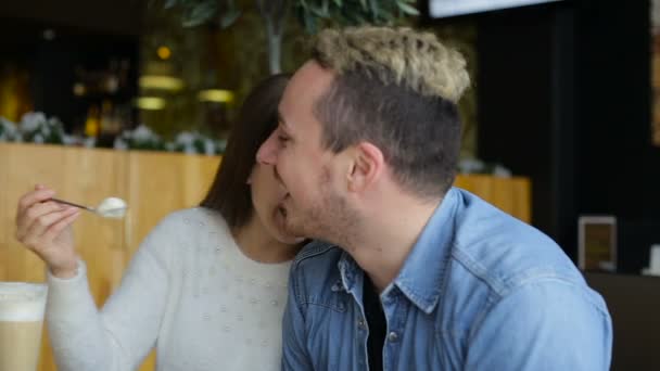 Двоє молодих, усміхнених і щасливих людей спілкуються в кафе — стокове відео