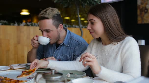 Pärchen redet und isst Pizza in Café in der Stadt — Stockvideo