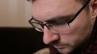 Tablet ile çalışan genç bir adam gözlüklü portresi