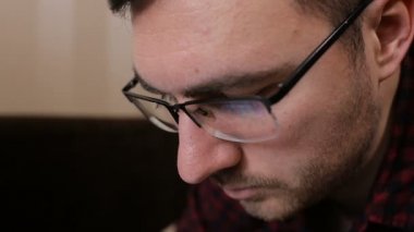 Tablet ile çalışan genç bir adam gözlüklü portresi