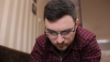 Tablet ile çalışan genç bir adam gözlüklü portresi