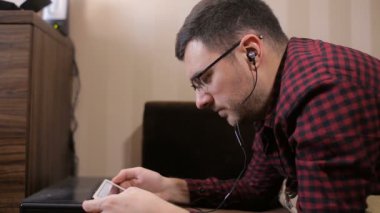 Beyaz adam dijital tablet kanepe ve müzik üzerinde kullanma