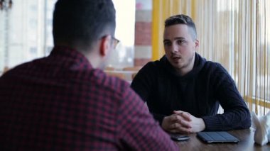 Bir masada bir kafe konuşan iki erkek arkadaşlar
