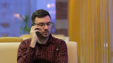 cep telefonu kafede üzerinde konuşan genç adam