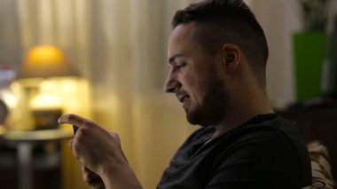 Mutlu delikanlı Smartphone'da evde oyun oynarken