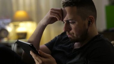 Video veya dinleme müzik evde tablet izleyen adamım
