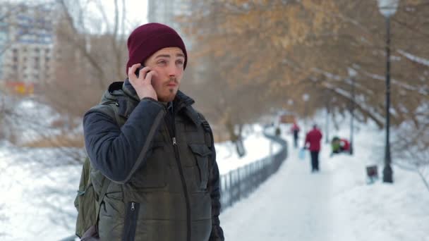 Hombre hablando por celular en el parque en invierno — Vídeos de Stock