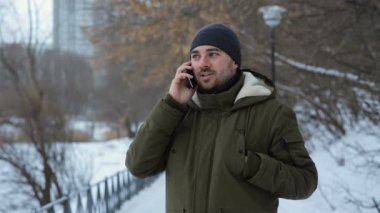Parkta cep telefonu üzerinde kış anda konuşan adam