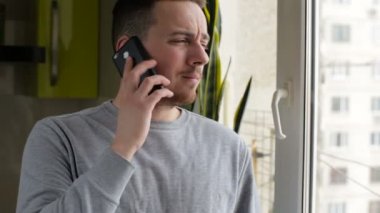 Evde pencere hazır cep telefonu üzerinde konuşan adam