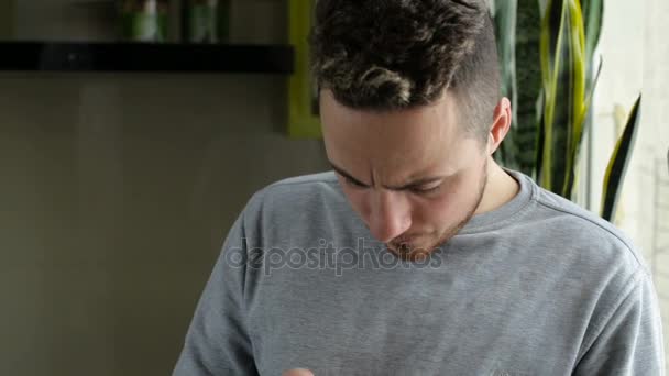 Ο άνθρωπος γραπτών μηνυμάτων στο smartphone από το παράθυρο στο σπίτι — Αρχείο Βίντεο