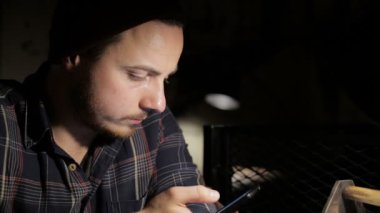Genç adam, gece bir barda smartphone kullanır