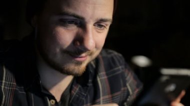 Genç adam bir restoran yakın çekim gece smartphone kullanır