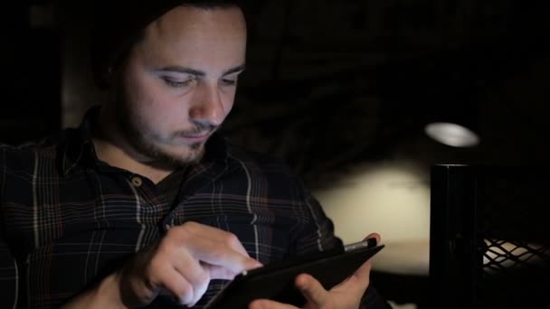 Hombre joven usando tableta en la cafetería en la noche — Vídeos de Stock