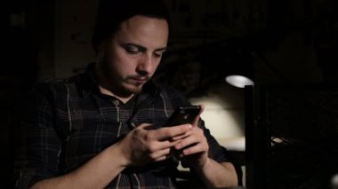 Genç adam gece kafede sms smartphone yazmak