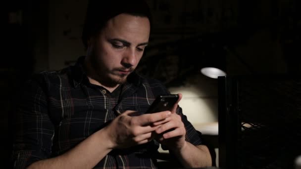 Młody człowiek Napisz sms smartphone w kawiarni w nocy — Wideo stockowe