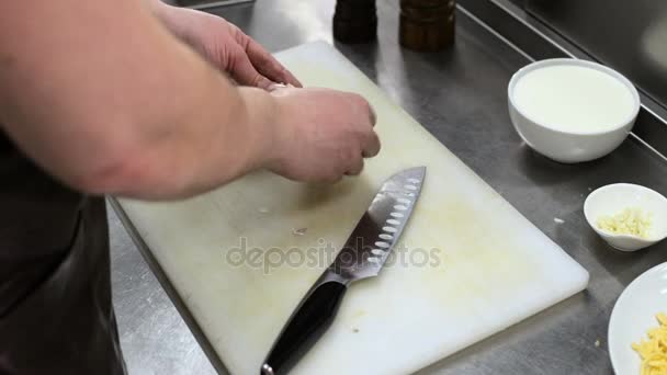 Handen van de kok gereinigd en gemalen knoflook. — Stockvideo