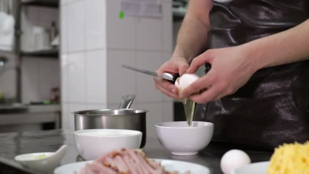 Schüssel mit Eigelb vorhanden. Hand des Chefs hält Eierschale — Stockvideo