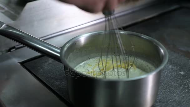 De chef-kok is koken de saus op het fornuis — Stockvideo