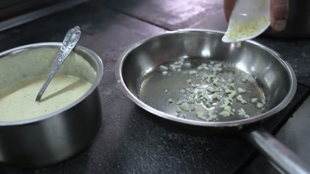 Chef-kok frituren knoflook op de pan — Stockvideo