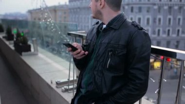 Çatı City üstünde hareket eden telefon ile sakallı genç yakışıklı adam