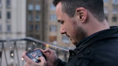 Çatı City üstünde hareket eden telefon ile sakallı genç yakışıklı adam