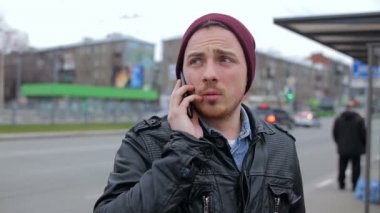 Adam otobüs durağında telefonda konuşuyor