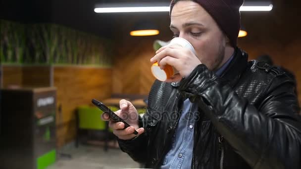 Man met behulp van de mobiele telefoon en koffie drinken in café — Stockvideo