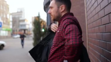 Genç adam tuğla duvar tarafından içinbeklediğini