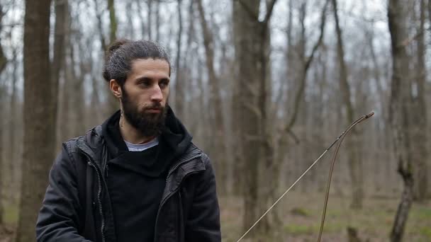 Man schiet met een strik in het bos — Stockvideo