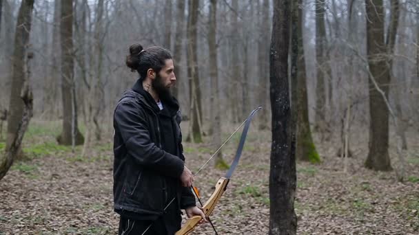 Hombre disparar con un arco en el bosque — Vídeos de Stock