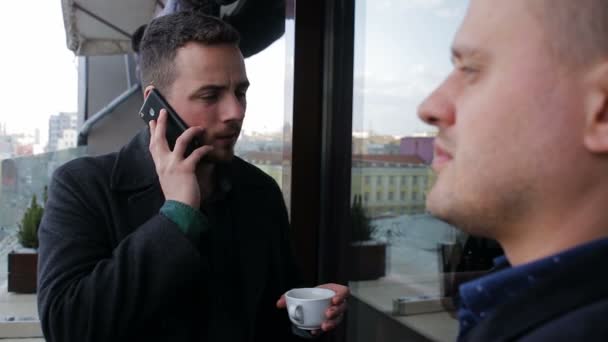 Twee jonge ondernemers spreken op het balkon in een restaurant — Stockvideo