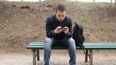 Dokunmatik ekran telefon parkta oynayan genç adam