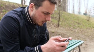 Dokunmatik ekran telefon parkta oynayan genç adam