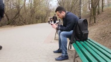 Dokunmatik ekran telefon parkta oynayan genç adam