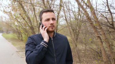 Genç adam parkta cep telefonu konuşurken
