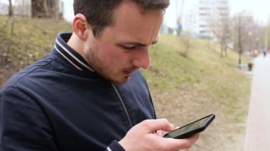 Adam cep telefonu ile parkta