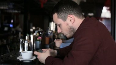 Yalnız adam otururken smartphone cep telefonu ile oyun oynama bar