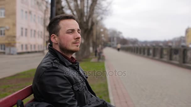 Ragazzo seduto sulla panchina sul lungomare — Video Stock
