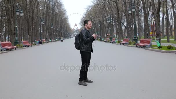 Un jeune homme danse dans le parc et écoute de la musique sur le smartphone — Video