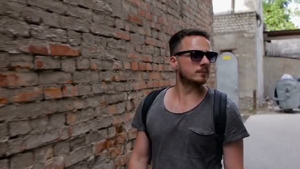 Egy turista sétál végig egy sikátorban közel egy téglafal. Lő slo-mo — Stock videók